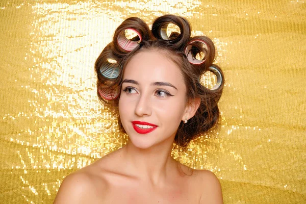 Menina bonita em encrespadores de cabelo isolado em ouro — Fotografia de Stock