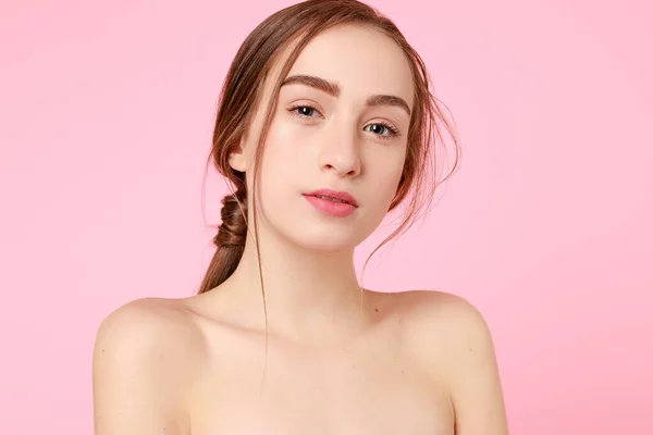 Mooi jong meisje aanraken haar perfecte huid op roze achtergrond. — Stockfoto