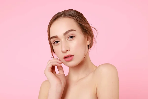 Bella ragazza toccando la sua pelle perfetta su sfondo rosa . — Foto Stock