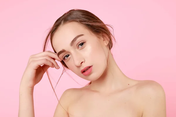 Hermosa joven tocando su piel perfecta sobre fondo rosa . —  Fotos de Stock
