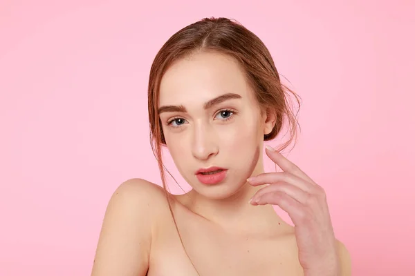 Hermosa joven tocando su piel perfecta sobre fondo rosa . —  Fotos de Stock