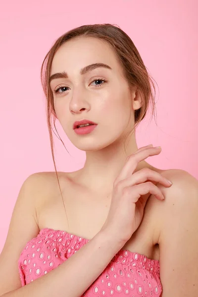 Hermosa joven tocando su piel perfecta sobre fondo rosa . — Foto de Stock