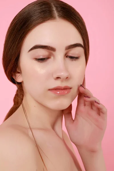 Beautiful young girl touching her perfect skin on pink background. — 스톡 사진