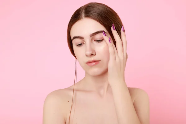 Beautiful young girl touching her perfect skin on pink background. — 스톡 사진