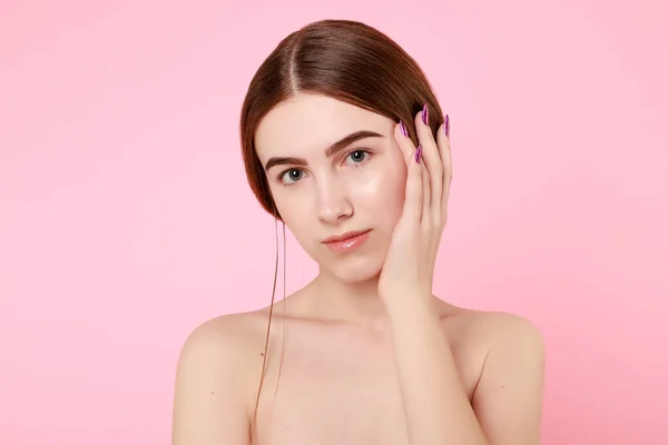 Beautiful young girl touching her perfect skin on pink background. — 스톡 사진