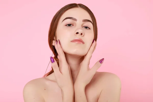 Beautiful young girl touching her perfect skin on pink background. — 스톡 사진