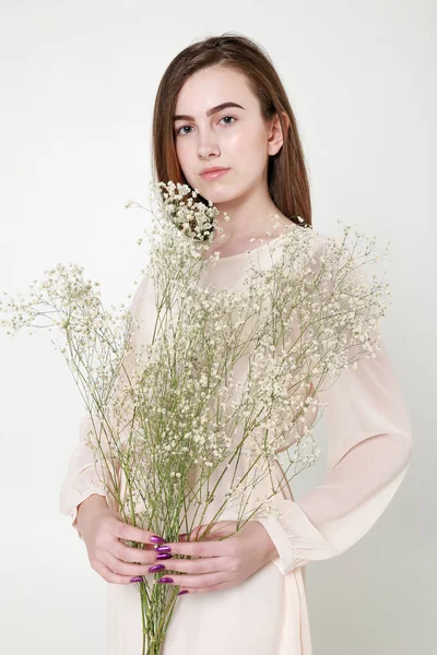 Mirada romántica rizada, ojos hermosos. Flores silvestres blancas en las manos . — Foto de Stock