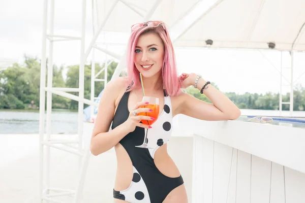Joven mujer alegre en traje de baño, tostadas con cóctel, beber fresco —  Fotos de Stock