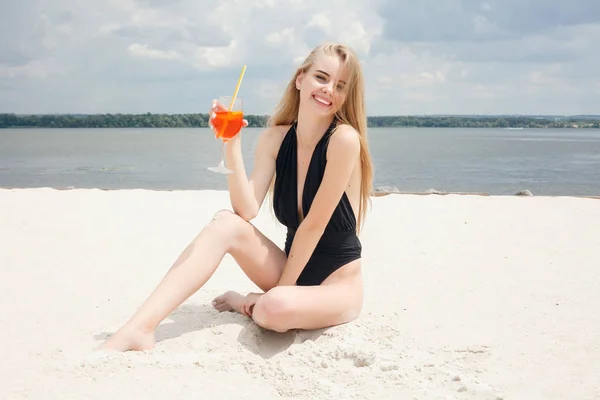 Joven mujer alegre en traje de baño, tostadas con cóctel, beber fresco —  Fotos de Stock