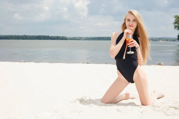 Junge fröhliche Frau im Badeanzug, prostet mit Cocktail zu, trinkt frisch — Stockfoto