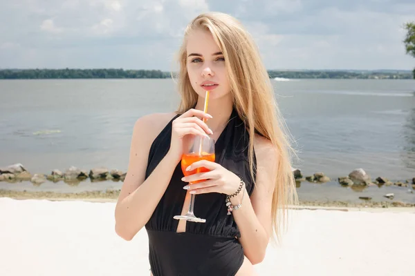 Ung glad kvinna i baddräkt, skålar med cocktail, dricker färsk — Stockfoto