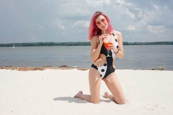 Jonge vrolijke vrouw in badpak, toasten met cocktail, fris drinken — Stockfoto