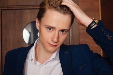 Okul çocuğunun portresi. Resmi olarak siyah takım elbise, kravat.