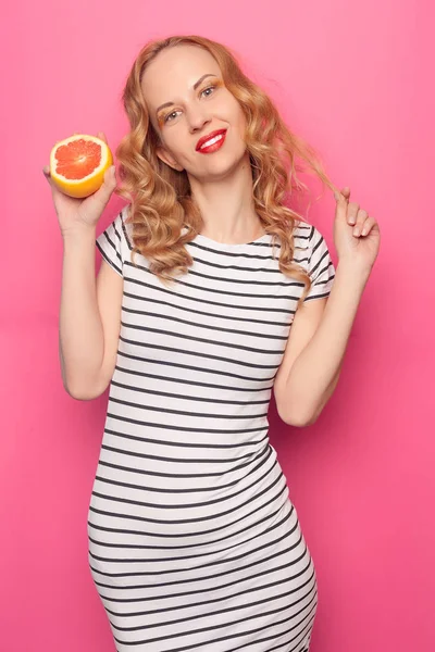 Chica joven divertida con mitades de naranja de pomelo fresco maduro —  Fotos de Stock