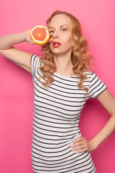 Chica joven divertida con mitades de naranja de pomelo fresco maduro — Foto de Stock