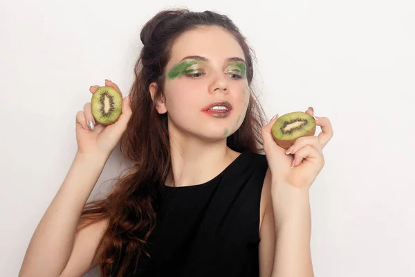 Šťastná mladá dívka jí půl kiwi — Stock fotografie