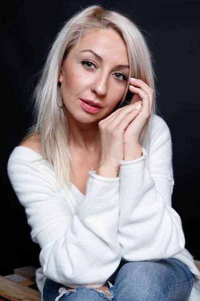 Porträtt av en vacker ung attraktiv kvinna i en vit tröja — Stockfoto