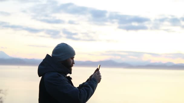 Ember Fényképet Készít Okostelefonjával Egy Havas Vadonban Naplementekor Visszapillantás Egy — Stock videók