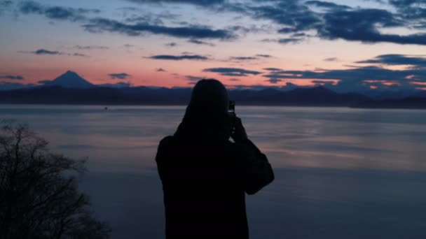 Adam Akıllı Telefonuyla Sunset Karlı Vahşi Bir Arazide Fotoğraf Çekiyor — Stok video