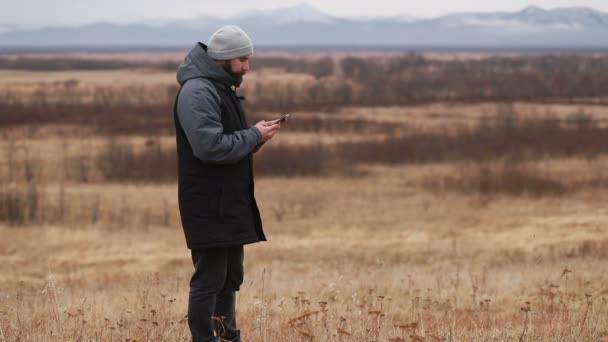 Человек Бородой Зимней Одежде Разговаривает Телефону Турист Идет Зимние Горы — стоковое видео