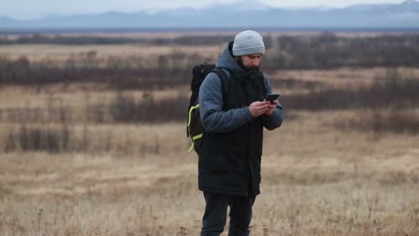 Человек Бородой Зимней Одежде Разговаривает Телефону Турист Идет Зимние Горы — стоковое видео