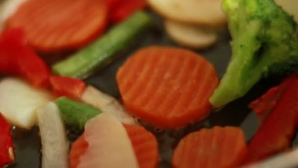 부엌에 프라이팬에서 야채를 요리하는 프라이팬에서 야채를 튀기는 건강에 채소들 — 비디오