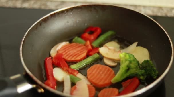 キッチンでフライパンで野菜を調理します ショットを閉じる スローモーション フライパンで焼きたての野菜を焼く ベジタリアンライフスタイル 健康食品 調理プロセス 鍋の野菜 — ストック動画