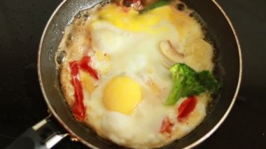 Sebzeli yumurta kızartma tavasında hazır. Kızartma tavasının üst görüntüsü. Yumurtalar kızarmış. Sebzeli omlet yapma süreci..