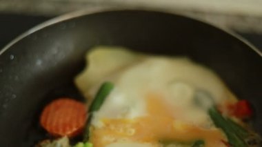 Sebzeli yumurta kızartma tavasında hazır. Kızartma tavasının üst görüntüsü. Yumurtalar kızarmış. Sebzeli omlet yapma süreci..