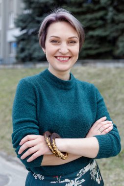 Yünlü bir kadın kazağının yakın plan parçası. Yeşil örgü elbiseli kız. Yeşil örülmüş süveter. Şık giyimli kız. Kadınların kışlık sıcak giysileri..