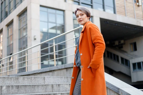 Stílusos Hölgy Fényes Narancssárga Kabátban Egy Városi Jelenetben Laptoppal Szünetben — Stock Fotó
