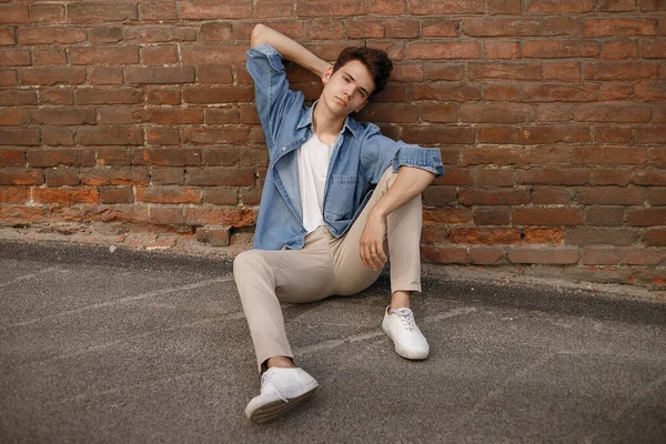 Junger Hipster Sitzt Seinem Blauen Jeans Knopfleiste Hemd Und Zeigt — Stockfoto