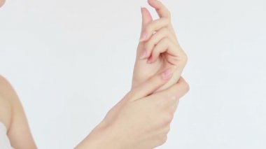 Güzellik, insanlar ve sağlık konsepti - el kremi süren genç bir kadının temiz ve bakımlı elleri, beyaz bir arka planda cilt bakımı. Yakın plan. Şehvetli kadın cildini nemlendirir. 4K, Ağır çekim