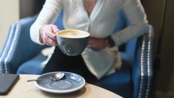 カフェでコーヒーを飲んでいる美しい思慮深い女性 コーヒーを飲む若い女性の半分の顔の肖像画 — ストック動画