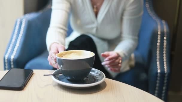 カフェでコーヒーを飲んでいる美しい思慮深い女性 コーヒーを飲む若い女性の半分の顔の肖像画 — ストック動画