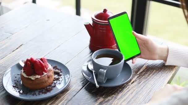 智能手机在一个绿色屏幕的手中在一个咖啡店 智能手机在一个彩色键绿色屏幕 新的技术概念关闭 — 图库视频影像