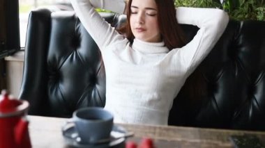 Rahat bir kanepede dinlenen ve hayal kuran mutlu genç bir kadın. Rahatlamış milenyum kızı başka tarafa bakıyor, gülümsüyor, evinde dinleniyor. Huzurlu bayan rüya görüyor, stres yok.