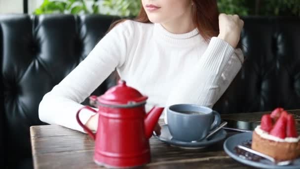 在咖啡馆里用漂亮女人的小玩意做的早茶 紧贴着漂亮的女性笑脸 用杯子喝着热饮料 微笑的女人在咖啡馆喝咖啡或喝茶时有着积极的情绪 — 图库视频影像