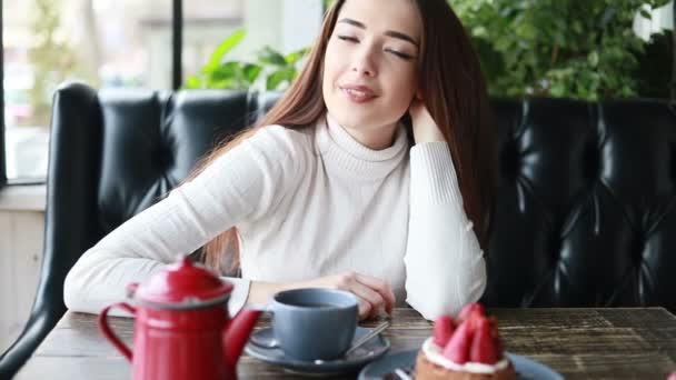 在咖啡馆里用漂亮女人的小玩意做的早茶 紧贴着漂亮的女性笑脸 用杯子喝着热饮料 微笑的女人在咖啡馆喝咖啡或喝茶时有着积极的情绪 — 图库视频影像