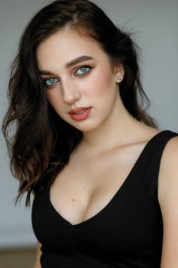 Siyah gömlekli, siyah tişörtlü, mutlu ve rahat bir yüz ifadesiyle kameraya bakıp üniversite fotoğrafı için poz veren genç, neşeli, güzel kızın portresini yakın plan çek..