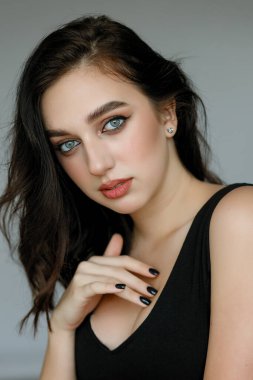 Siyah gömlekli, siyah tişörtlü, mutlu ve rahat bir yüz ifadesiyle kameraya bakıp üniversite fotoğrafı için poz veren genç, neşeli, güzel kızın portresini yakın plan çek..