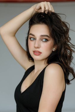 Siyah gömlekli, siyah tişörtlü, mutlu ve rahat bir yüz ifadesiyle kameraya bakıp üniversite fotoğrafı için poz veren genç, neşeli, güzel kızın portresini yakın plan çek..