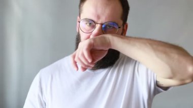 Genç adamın burnu akıyor, burnu kollarıyla sürtüyor, hastalanıyor, yağmurlu havada üşütüyor. Hijyenik olmayan alışkanlık.