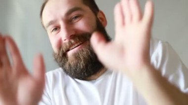 Kayıtsız bir adamın portresi, sıradan giysiler içinde omuz silkip yanlış anlaşılmaları ifade ediyor ya da elleri kaldırıp gri arka planda ağır çekimde izole edilmiş bir şekilde hiçbir şey yapamıyor. Duyguların kavramı