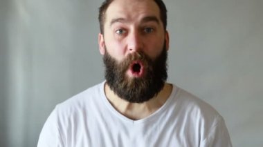 Yakışıklı, tıraşsız bir adamın hayretle bağıran portresi ve buna inanamıyorum, stüdyoda beyaz arka planda izole edilmiş. Duyguların kavramı