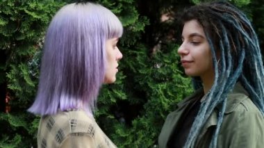 Lezbiyen LGBT kadın öpücüğü gün ışığında dışarıda. Güneşin altında birbirini öpen binlerce yıllık güzel kız arkadaşlar. Rastalı kadın..