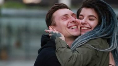 Genç ve mutlu bir çift sokakta eğleniyor. El ele tutuşan çift. Birbirine aşık çiftler birbirlerine sarılıp eğleniyorlar. Rasta saçlı kadın. öpücük