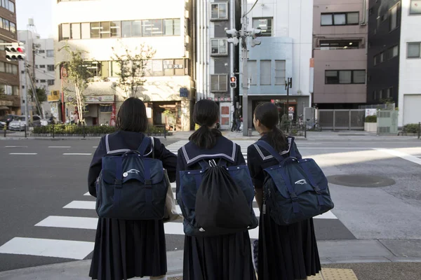 Японский студент ждет на перекрестке Лицензионные Стоковые Изображения