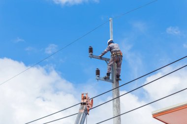 Elektrikçiler Kablo Tamir Servisi, vinç kamyonunda çalışan işçiler yüksek voltaj iletim hattını tamir ediyor, elektrik direğinin elektrik hattını kuruyorlar..