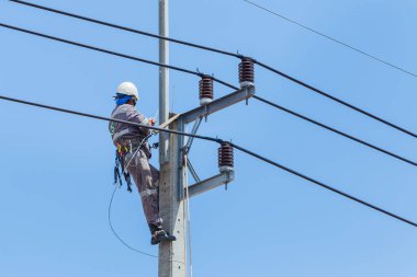 Elektrikçiler Kablo Tamir Servisi, vinç kamyonunda çalışan işçiler yüksek voltaj iletim hattını tamir ediyor, elektrik direğinin elektrik hattını kuruyorlar..